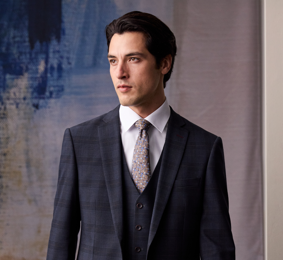 Man wearing navy, three piece suit and white shirt
