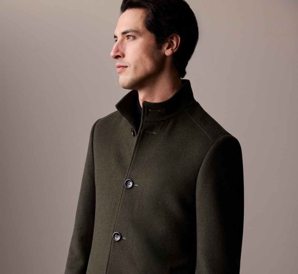 Man wearing dark green, high collar, tweed jacket